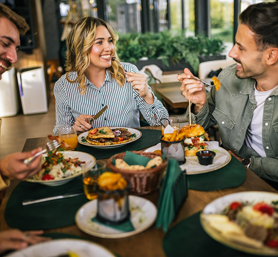 Smiling people at table enjoying a meal
