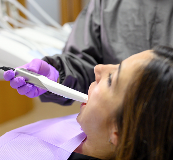 Woman having teeth scanned for digital impressions