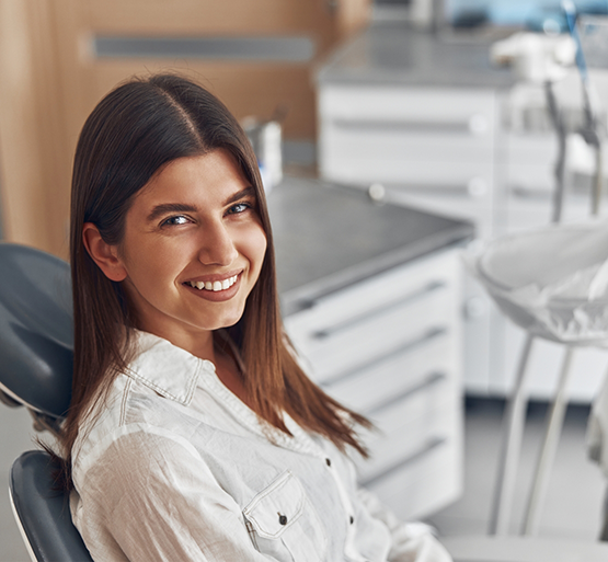 Woman sitting in dental chair smiling