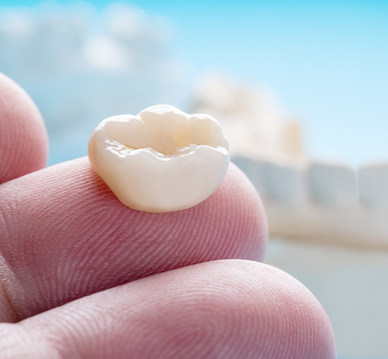 Close up of dental crown on finger
