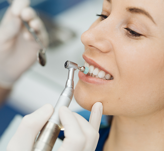 Female patient having teeth cleaned with electric brush