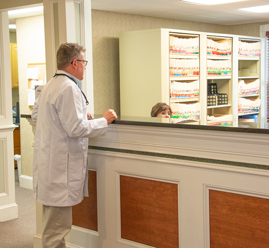 Dentist talking to team member at front desk