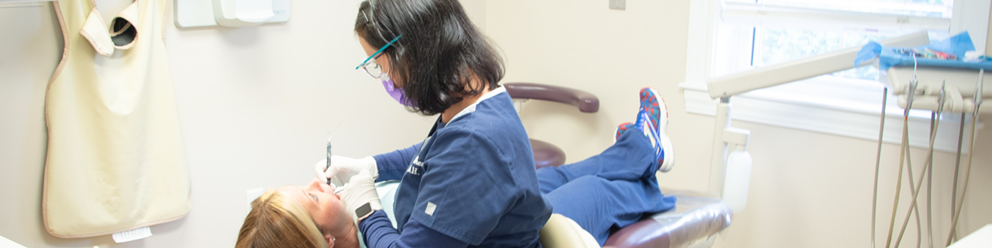 Patient having teeth cleaned by female dentist