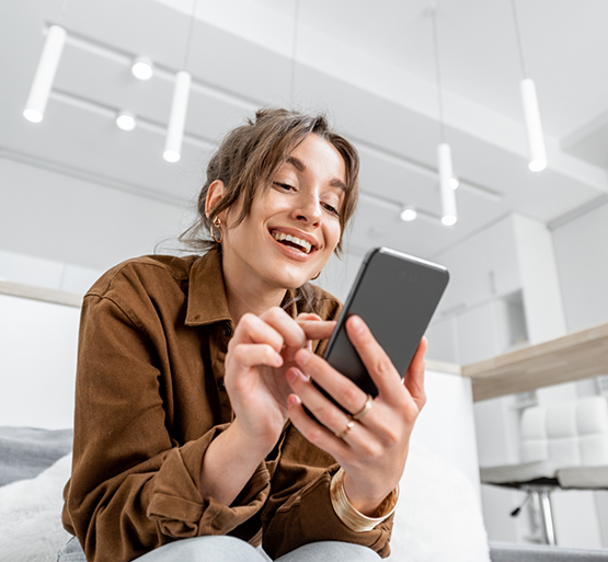 Woman sitting on couch looking at cell phone