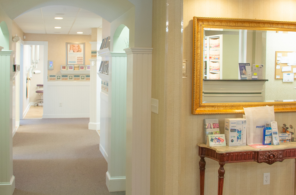 Hallway, decorative table, and mirror in dental office