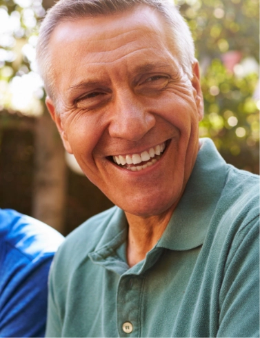 Close up of older man in green shirt smiling